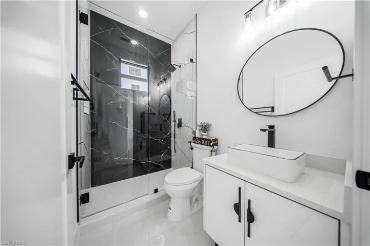 Full bathroom with vanity and a marble finish shower