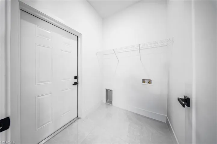 Washroom featuring light tile patterned floors and washer hookup