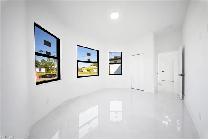 Unfurnished bedroom with multiple windows, a raised ceiling, and recessed lighting