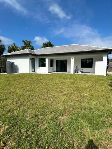 Rear view of house featuring a yard