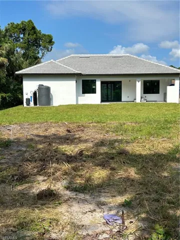 Back of property with a lawn