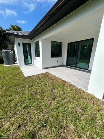 Rear view of property with a patio and a lawn