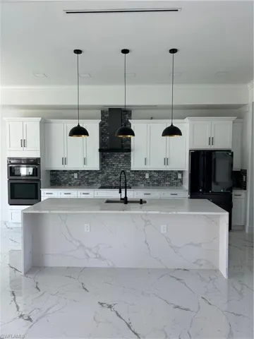 Kitchen with decorative light fixtures and a kitchen island with sink
