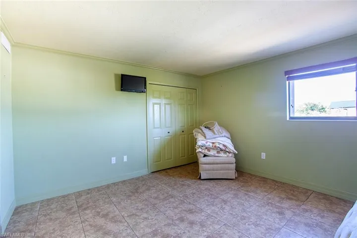 Living area with crown molding and baseboards