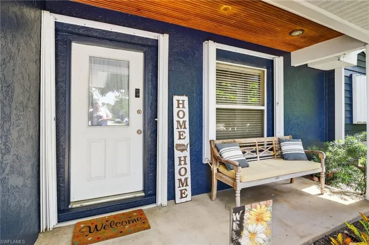 Property entrance featuring a porch and stucco siding