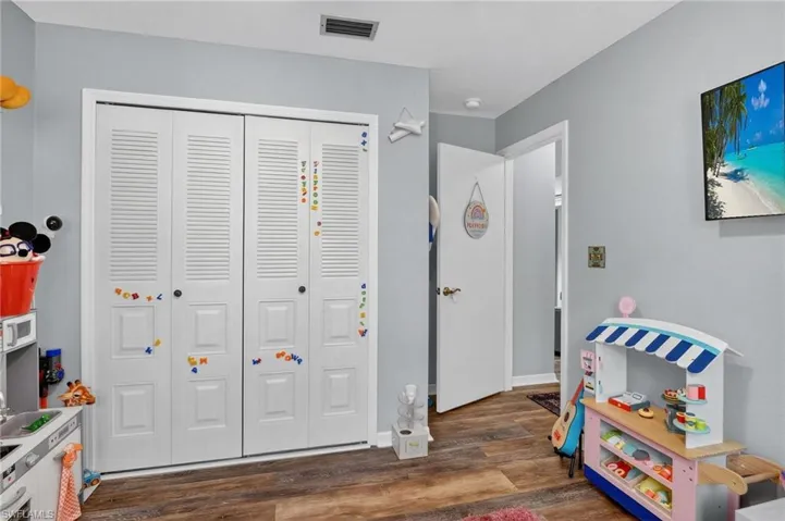 Recreation room featuring wood finished floors and baseboards