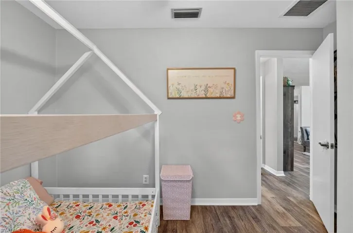 Bedroom featuring wood finished floors and baseboards
