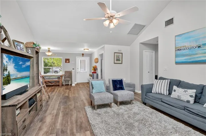 Living room featuring wood finished floors, ceiling fan, and high vaulted ceiling