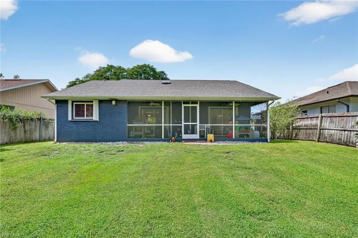 Back of property featuring a fenced backyard, a sunroom, and stucco siding