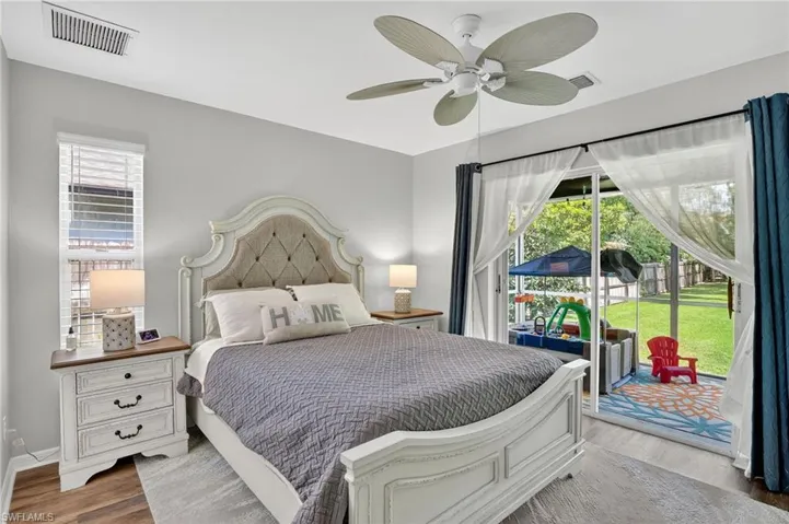 Bedroom featuring access to exterior, wood finished floors, and ceiling fan