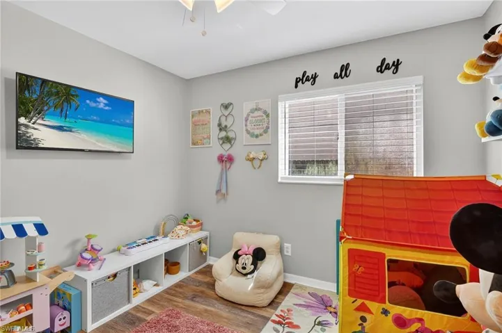 Rec room with wood finished floors and ceiling fan