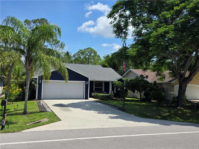Single story home featuring a front lawn, concrete driveway, an attached garage, and a shingled roof