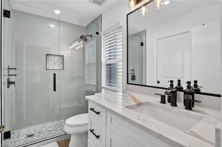 Bathroom featuring vanity, a stall shower, and recessed lighting