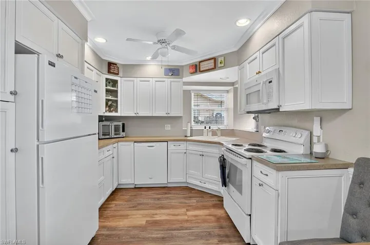 Kitchen featuring white appliances, white cabinetry, a ceiling fan, recessed lighting, and light wood finished floors