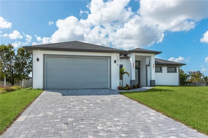 View of front of home with a front lawn and a garage