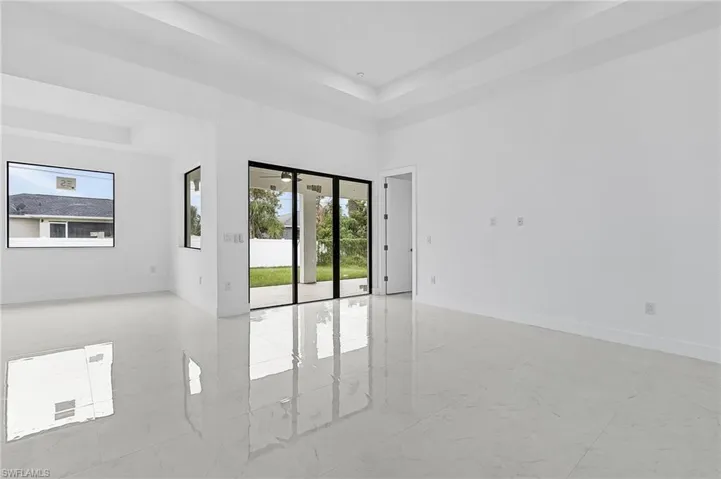 Unfurnished room with a raised ceiling and plenty of natural light