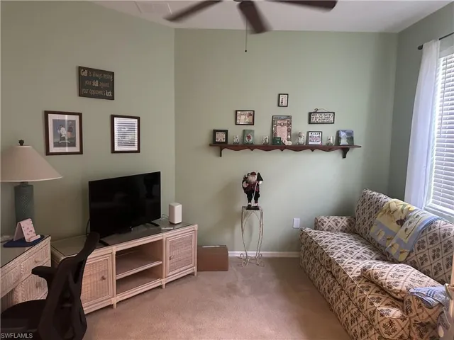 Carpeted room featuring a ceiling fan, light green wall tones, and a window with blinds and sheer curtains