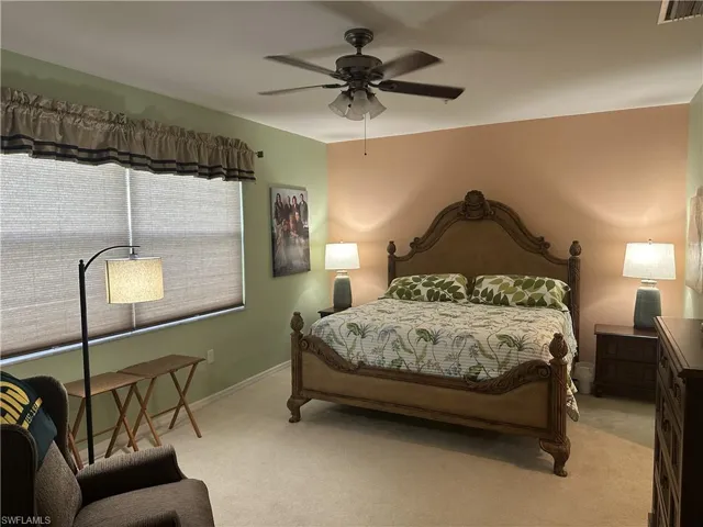 Spacious room featuring carpet flooring, a ceiling fan with integrated lighting, and a large window with cellular shades