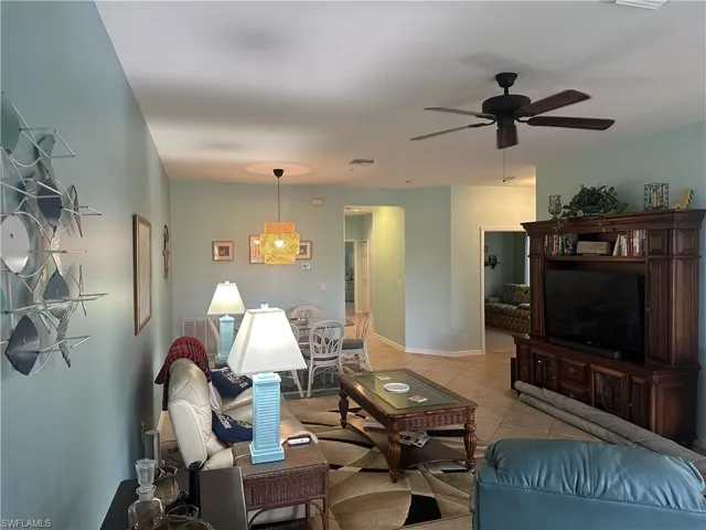 Open-concept living area with light-colored wall paint and tile flooring