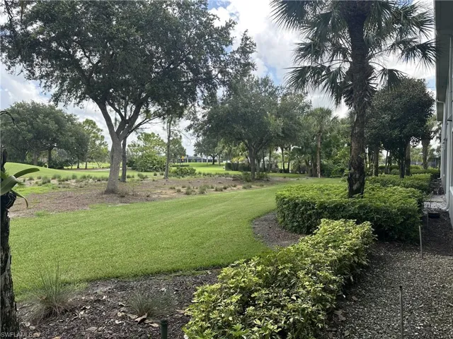 Expansive green lawn bordered by manicured shrubs and mature trees