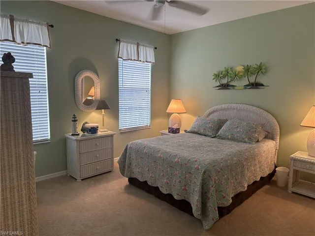 Wall-to-wall carpeting in a neutral tone complements the soft green wall finish