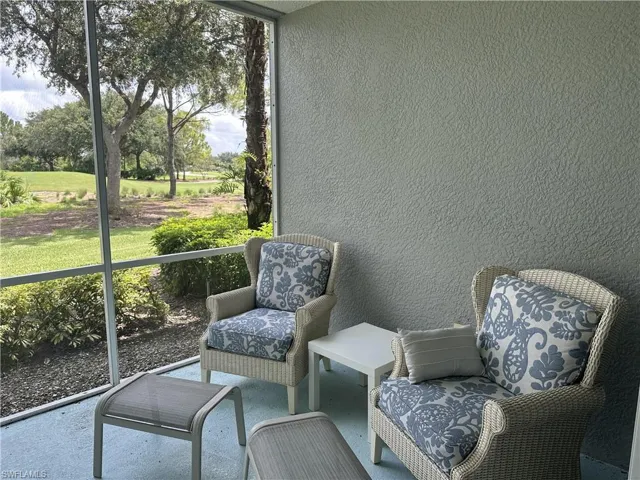 Screened patio featuring a textured exterior wall and a vibrant green landscape beyond