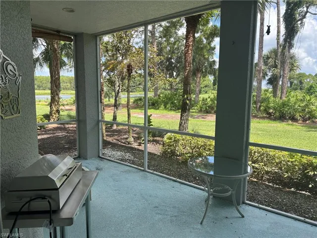 Screened patio featuring a painted concrete floor and a natural landscape beyond with a visible body of water