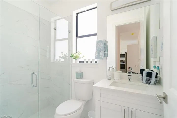 Bathroom featuring vanity, toilet, and an enclosed shower