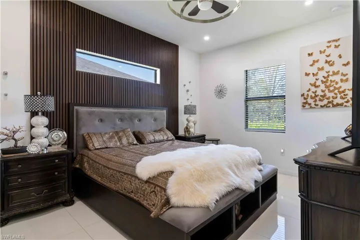 Bedroom featuring light tile patterned floors, an accent wall, recessed lighting, and a ceiling fan