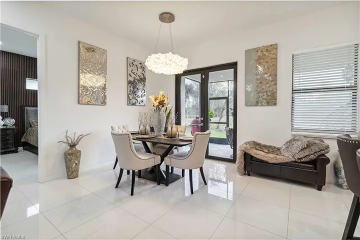Tiled dining area with a chandelier and french doors