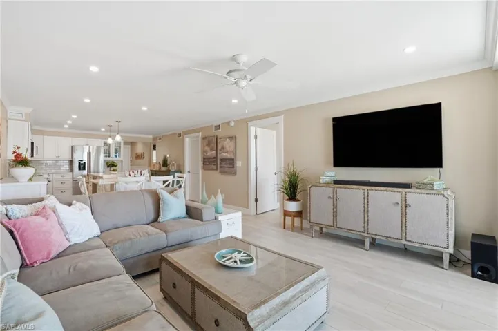 Living area with recessed lighting, crown molding, light wood-style floors, and a ceiling fan