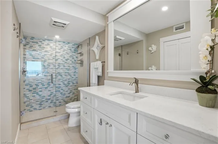 Full bath featuring vanity, a shower stall, and light tile patterned flooring