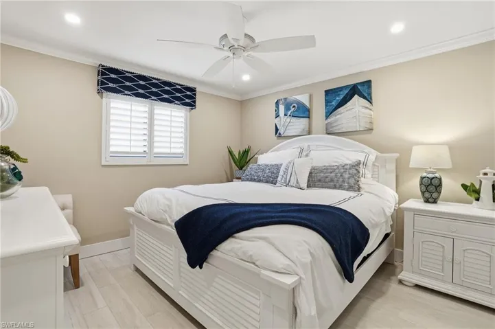 Bedroom with light wood-type flooring, ornamental molding, ceiling fan, and recessed lighting