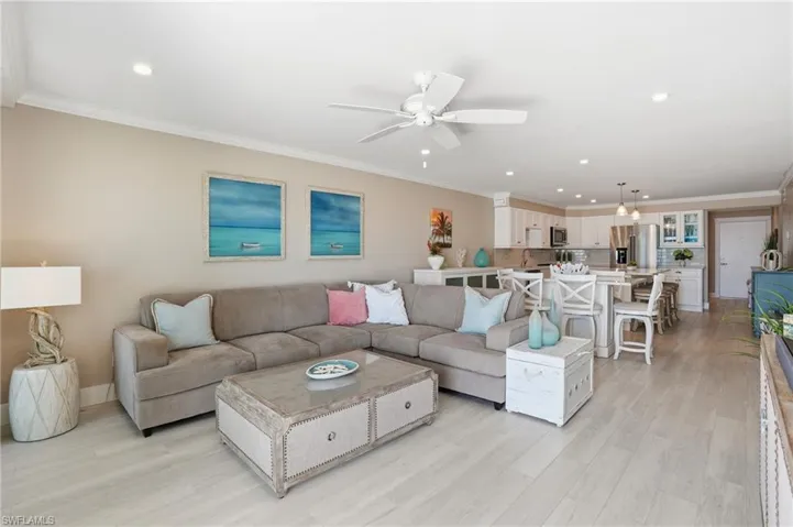Living room featuring crown molding, recessed lighting, light wood-style flooring, and a ceiling fan