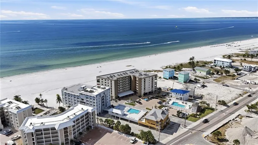 Drone / aerial view of unending shoreline and a pool area