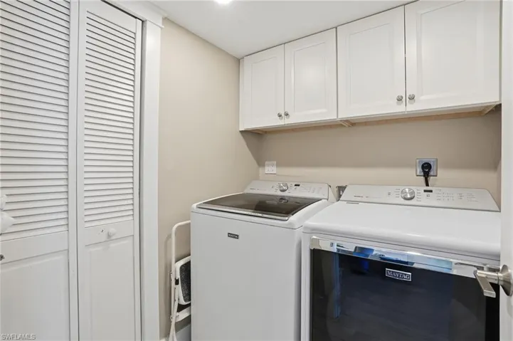 Washroom featuring cabinet space and separate washer and dryer
