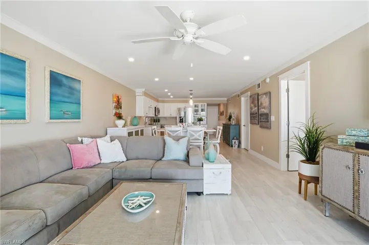 Living room with crown molding, recessed lighting, light wood-style floors, and a ceiling fan