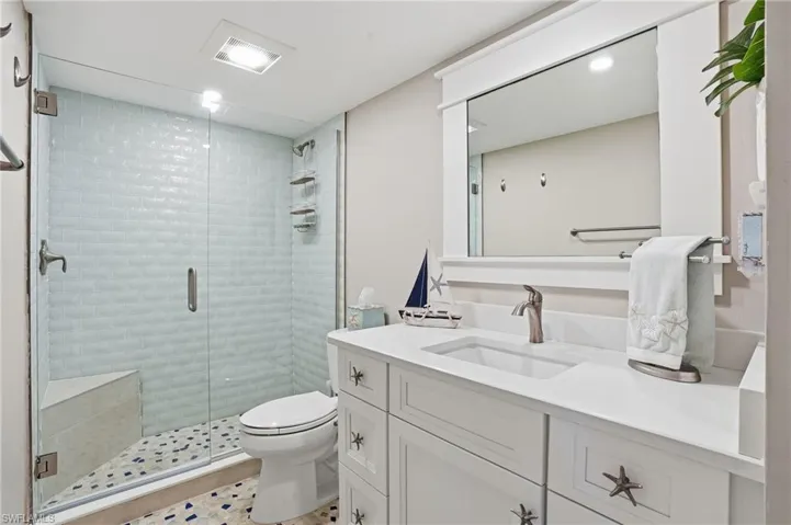 Bathroom featuring a shower stall, vanity, and light tile patterned flooring