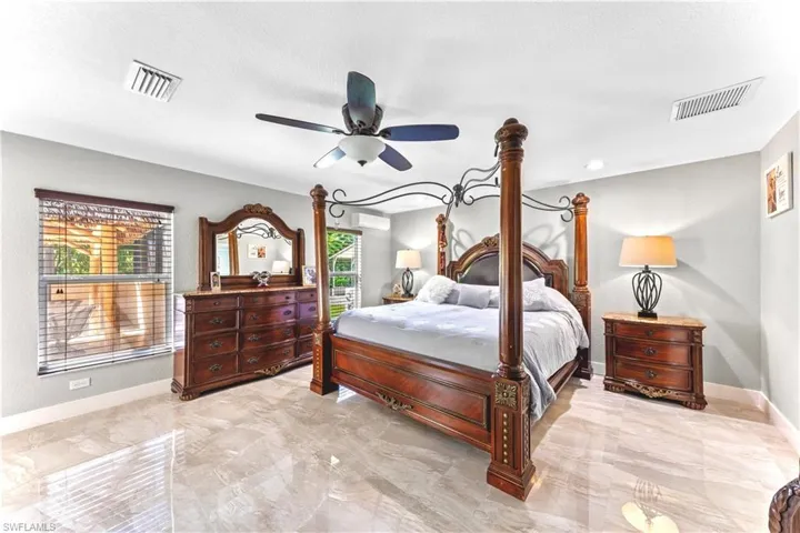 Bedroom featuring a textured ceiling, ceiling fan, and a wall mounted AC