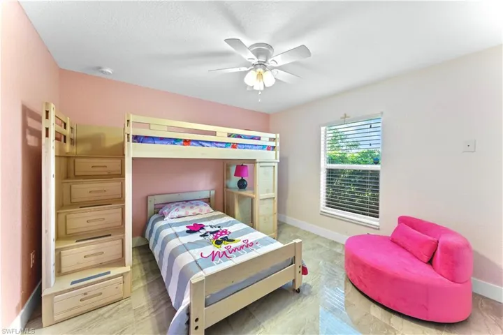 Bedroom featuring ceiling fan, hardwood / wood-style flooring, and a textured ceiling