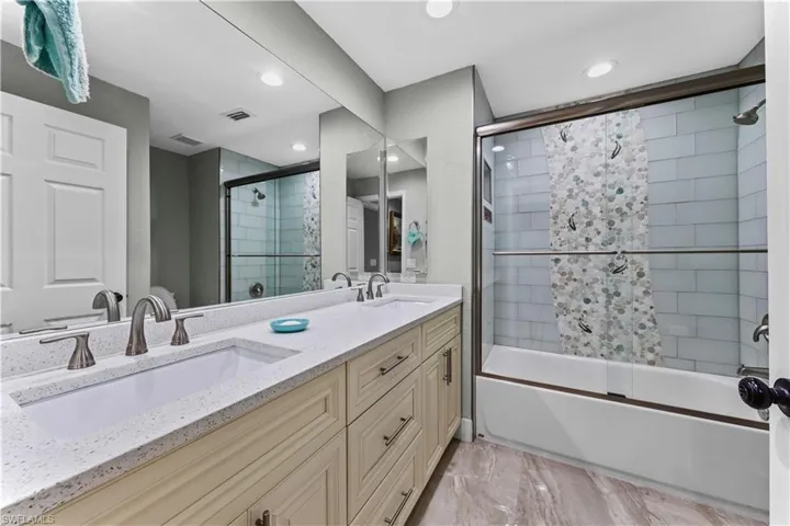 Bathroom with combined bath / shower with glass door and vanity