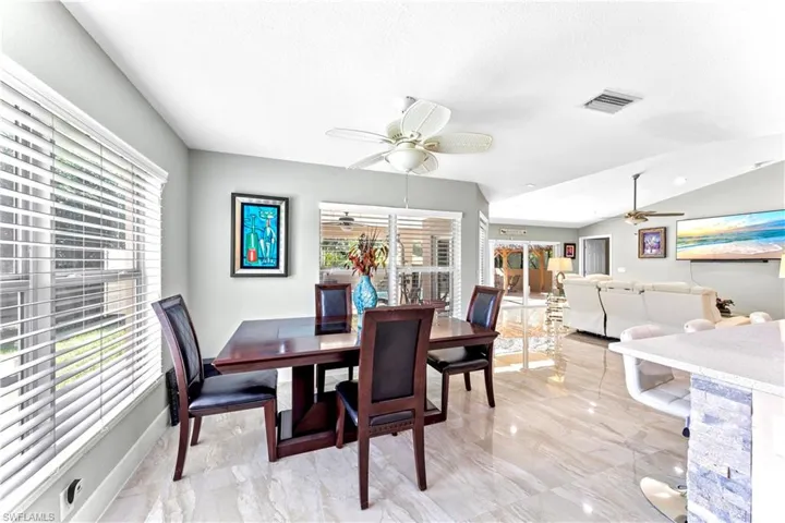Dining room featuring a textured ceiling, vaulted ceiling, and ceiling fan