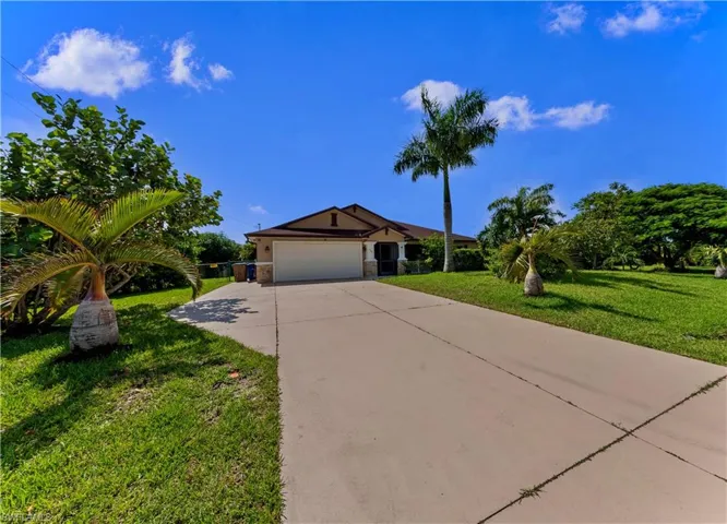 Ranch-style home with a front yard and a garage