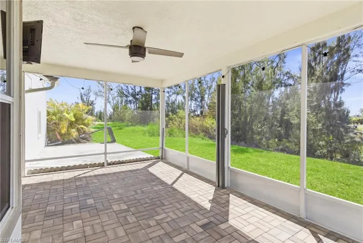 Screened lanai with breathtaking sunsets over the canal, surrounded by lush tropical landscaping—a perfect outdoor retreat.