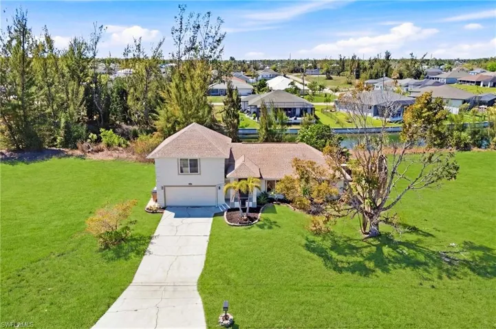 From above, the home’s striking façade, tropical surroundings, and serene neighborhood setting are fully revealed, making a lasting first impression.