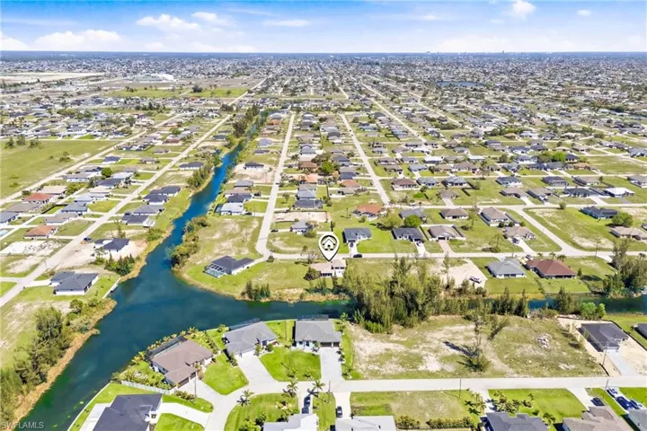 A stunning bird’s-eye view of the quiet NW neighborhood, highlighting well-kept homes, tree-lined streets, and the serene waterfront lifestyle just steps from your front door.