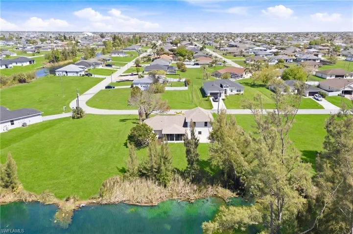 Elevated perspective shows this move-in ready home’s lush grounds, prime neighborhood location, and waterfront lifestyle.