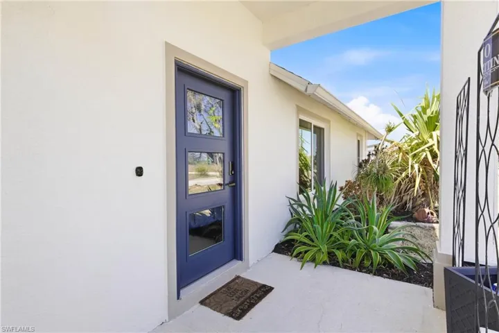 Bold and beautiful, the vibrant blue front door sets the tone for this stylish waterfront home, offering charm, character, and instant curb appeal.