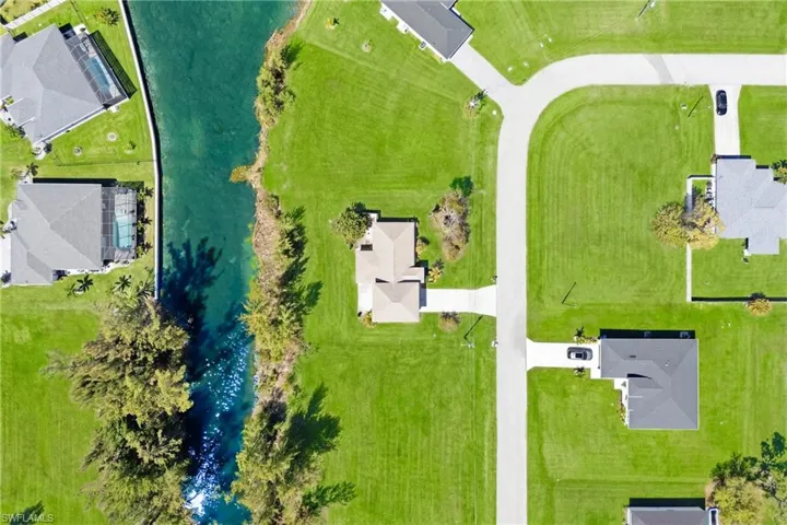 From above, the home’s open layout, canal access, and tropical surroundings highlight its beauty and location.
