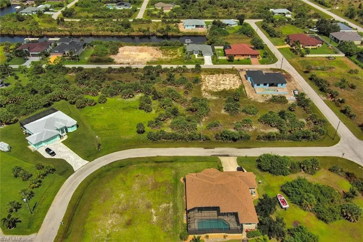 Aerial view of property and surrounding area with nearby suburban area